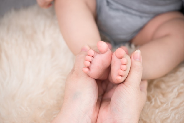 Close dos pés de um bebê e de sua mãe