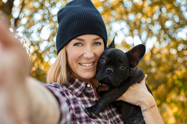 Close em jovem feliz com cachorro ao ar livre no outono