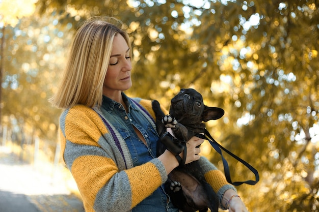 Close em jovem feliz com cachorro ao ar livre no outono