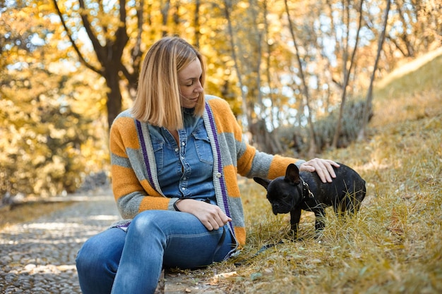 Close em jovem feliz com cachorro ao ar livre no outono