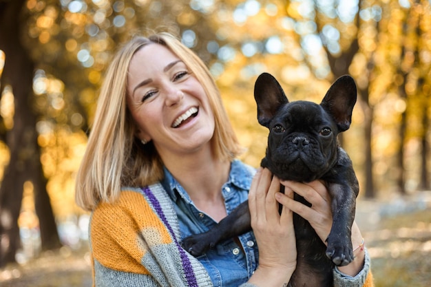 Close em jovem feliz com cachorro ao ar livre no outono