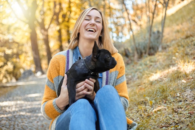 Close em jovem feliz com cachorro ao ar livre no outono