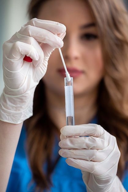 Foto close, enfermeira segurando um teste de laboratório de cotonete nasal para coronavírus ou covid-19