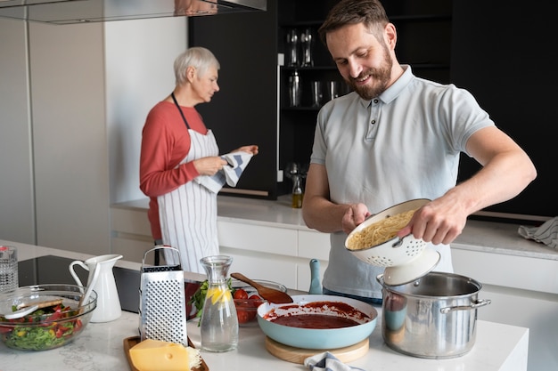 Foto close no filho cozinhando para a mãe