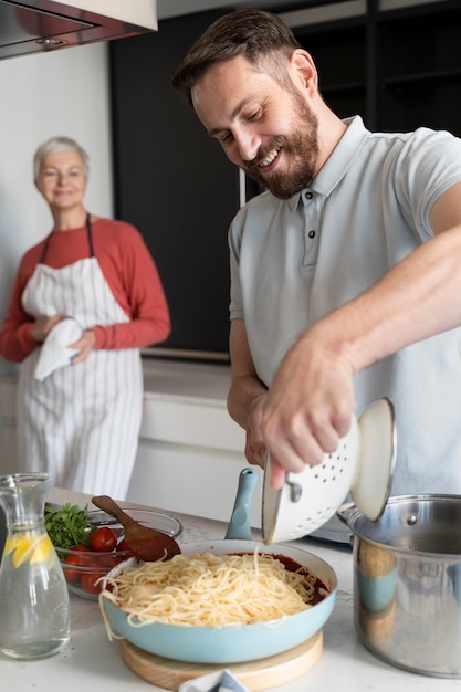 Foto close no filho cozinhando para a mãe