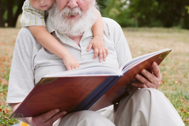 Close-up abuelo y nieto leyendo