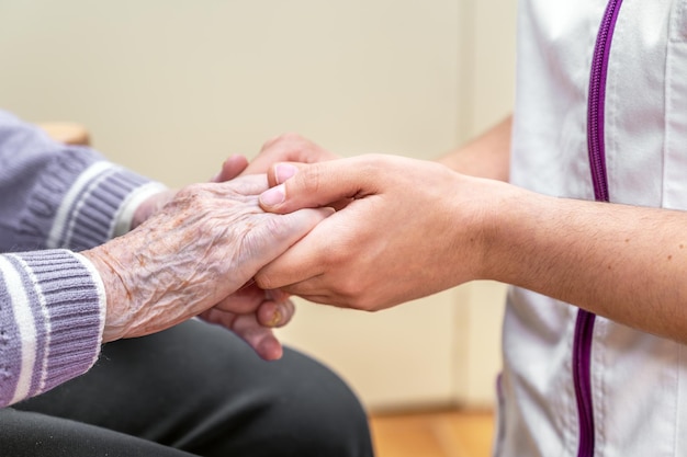 Foto close-up ältere frau hand mit ihrer pflegekraft, die hände zusammenhält, pflegekraft besuch zu hause pflege zu hause und pflegeheim konzept person