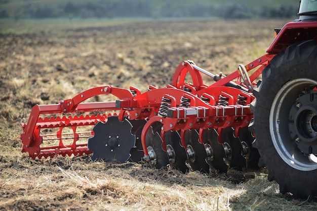 Foto close-up agrícola do arado na terra, maquinaria agrícola.