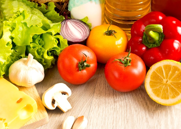 Close-up de alimentos, verduras, frutas, champiñones, queso en una mesa de madera