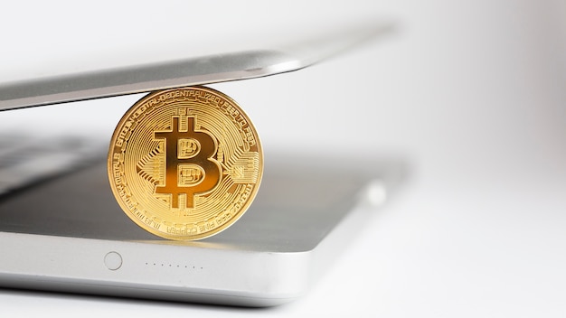 Close-up bitcoin con laptop desenfocada