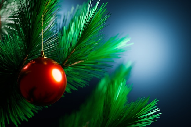 Close-up de una bola de Navidad de color rojo brillante colgando de un árbol de Navidad en el fondo