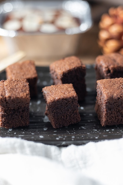 Close-up Bolo de chocolate mini brownie, sobremesa com leite em um fundo escuro em uma mesa de madeira.