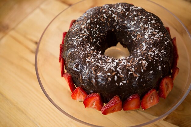 Close-up de bundt cake rodeado de fresas en la cafetería.