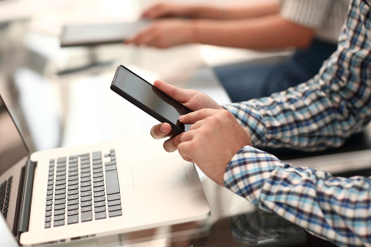Foto close up.business hombre con un teléfono inteligente sentado en su escritorio. personas y tecnologia