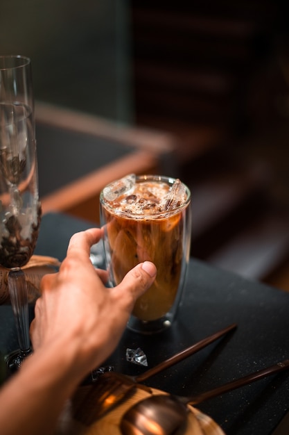 Foto close-up de café helado servido en la mesa negra en la cafetería.