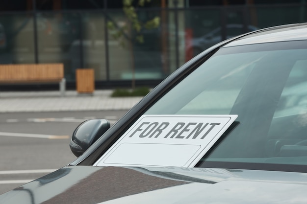 Foto close-up de coche nuevo con cartel en la ventana que se sugiere alquilar