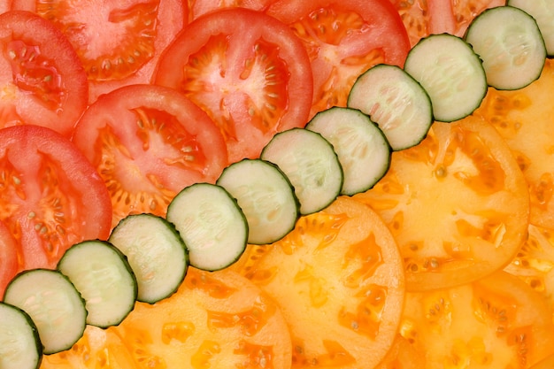 Foto close up cortado dos tomates e dos pepinos como o fundo. legumes, nutrição adequada, dieta
