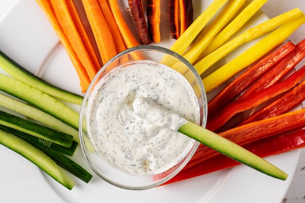 Close up de crema de inmersión con palos de verduras coroful.