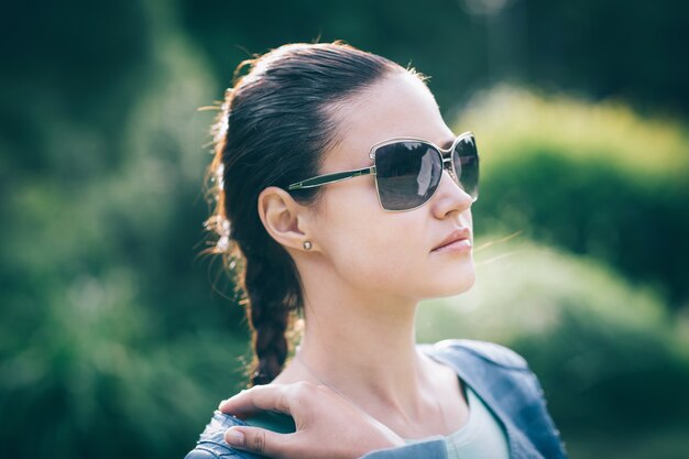 Close up.cute jovem mulher em óculos de sol. foto em fundo desfocado