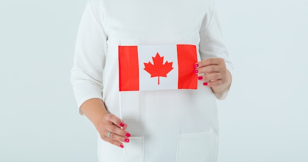 Close-up da bandeira do Canadá em mãos femininas.