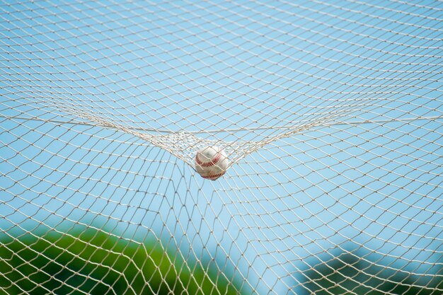 Foto close-up da bola na rede contra o céu na quadra