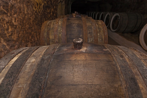 Close-up da cortiça de carvalho, uma velha adega com barricas de carvalho, barricas para vinho em caves antigas