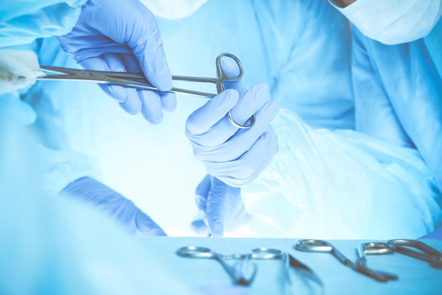 Close-up da equipe médica realizando operação. Grupo de cirurgiões no trabalho está ocupado com o paciente. Medicina, veterinária ou de saúde e emergência hospitalar.