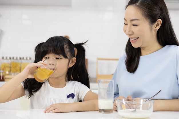 Close-up da família asiática bebendo suco de laranja