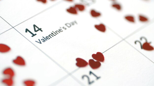 Close-up da folha de calendário com data de 14 de fevereiro com lindos corações de papel vermelho dia dos namorados