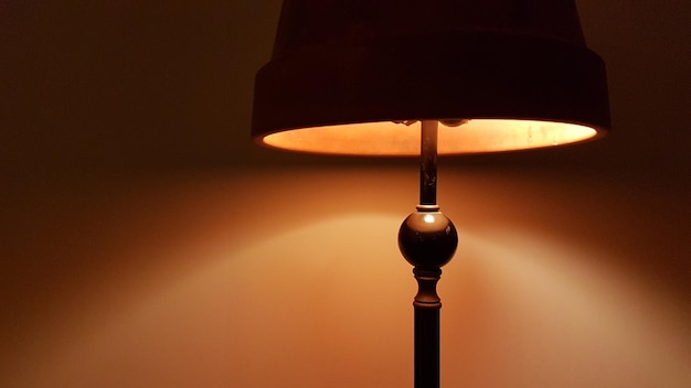 Close-up da lâmpada iluminada contra a parede
