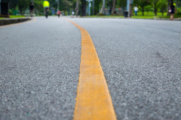 Close-up da linha amarela no parque público com exercício de pessoas e andar de bicicleta para uma boa saúde backgro