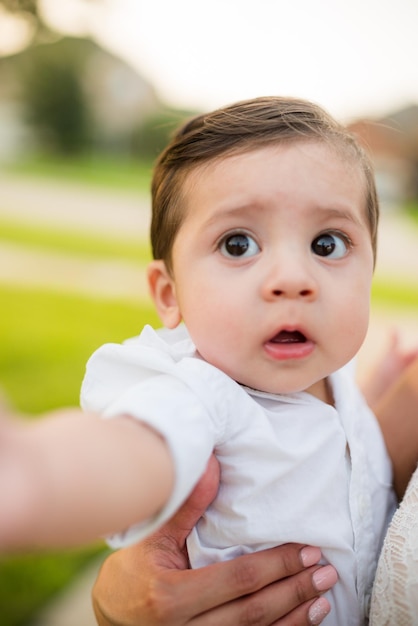 Foto close-up da mão da mãe segurando o bebê no campo