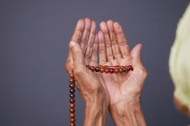 Close-up da mão de mulheres idosas rezando no ramadã