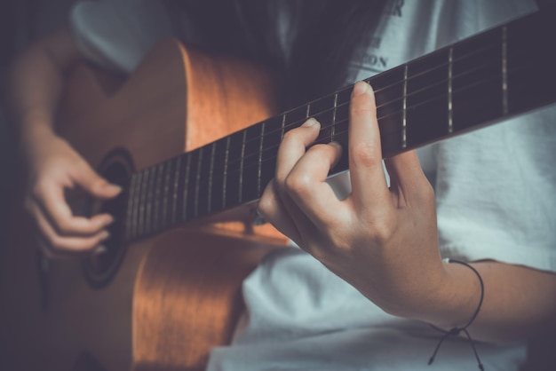 Close-up da mão de mulheres tocando violão