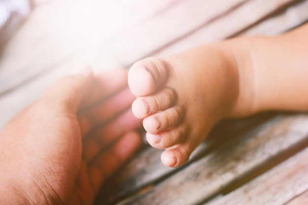 Foto close-up da mão pelo pé do bebê