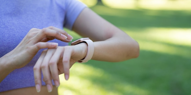 Close-up da mão tocando smartwatch com aplicativo de saúde no gadget de tela para estilo de vida ativo de fitness executando treinamento ao ar livre