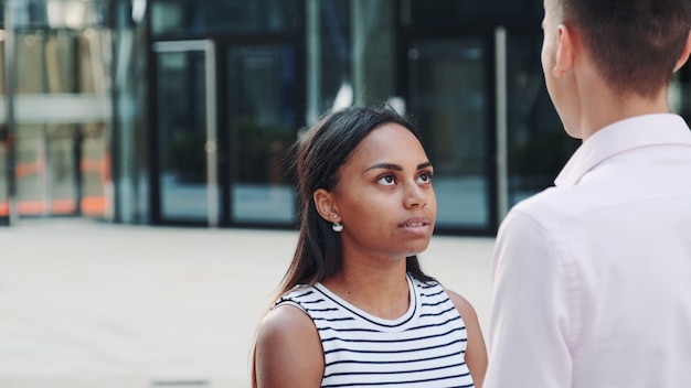 Close-up da menina de raça mista brigando com o namorado ao ar livre e depois deixá-lo sozinho