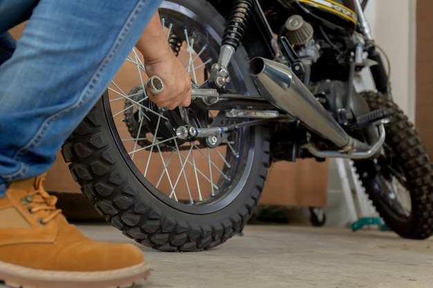 Close-up da motocicleta da fixação da mão do homem novo, passatempo mecânico e conceito dos reparos.