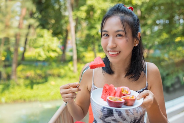 Close-up da mulher levantou um prato de comer frutas com melancia e maracujá Garota gosta de frutas para o almoço conceito de dieta de bem-estar Conceito de saúde