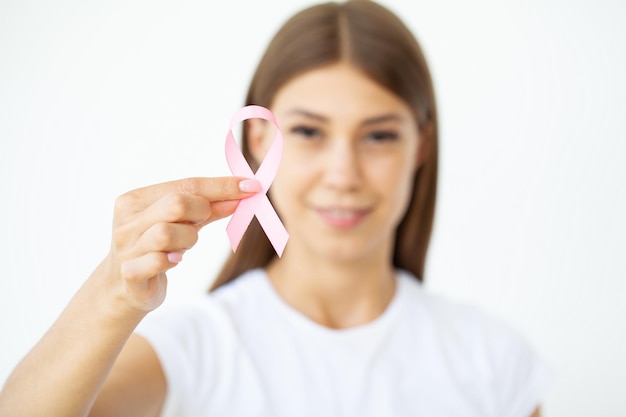 Close-up da mulher mostrando a fita rosa, simbolizando o câncer de mama