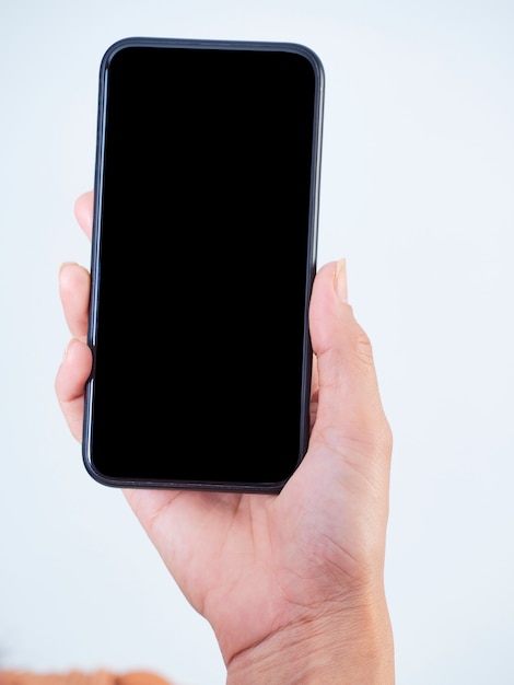 Close-up da mulher segurando o smartphone com uma tela em branco