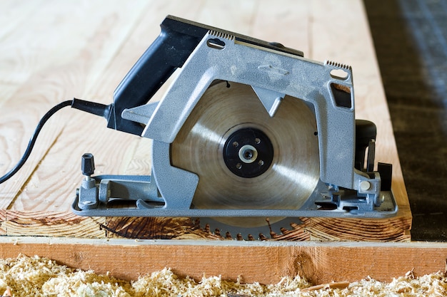 Close-up da nova serra elétrica circular poderosa moderna cortando pranchas de madeira.