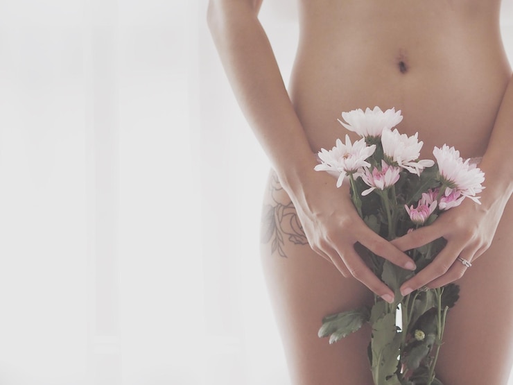 Foto close-up da parte média da mulher de pé com um buquê contra um fundo branco