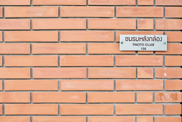 Foto close-up da placa de identificação na parede de tijolos
