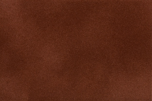 Foto close up da tela da camurça do marrom escuro. textura de veludo.