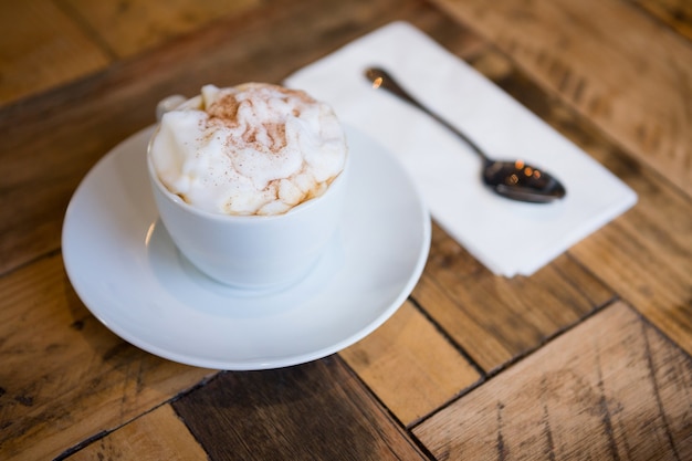 Close-up da xícara de café servida na mesa de madeira do refeitório