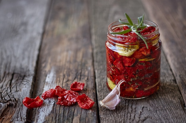 Foto close-up das glas hausgemachte sonnengetrocknete tomaten mit provenzalischen kräutern, knoblauch und olivenöl