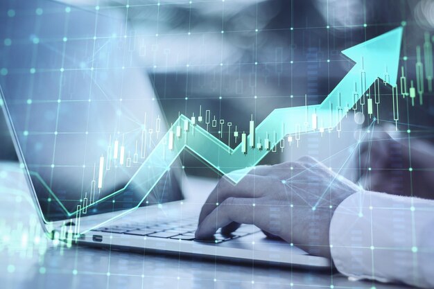 Close-up das mãos do empresário usando laptop com crescente seta castiçal verde no fundo desfocado Mercado de crescimento financeiro e conceito de comércio Dupla exposição
