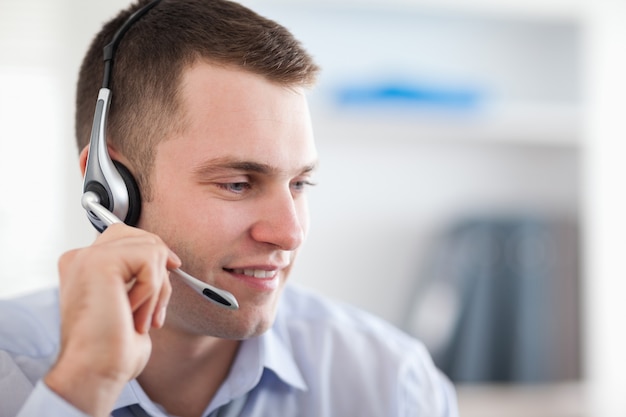 Close up de agente de call center jovem falando com o cliente