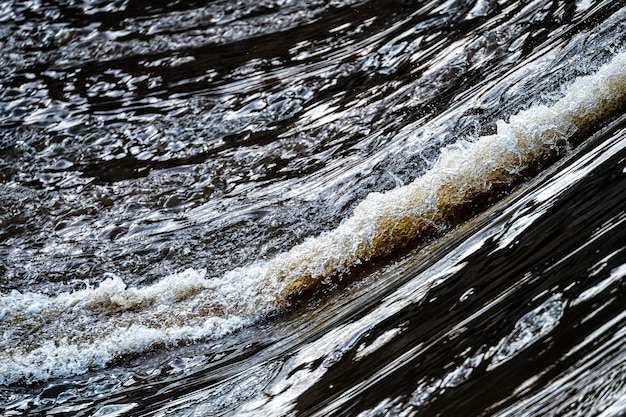 Close-up de água corrente salpicos de água rápida de um rio de água branca ou fluxo de água borbulhante